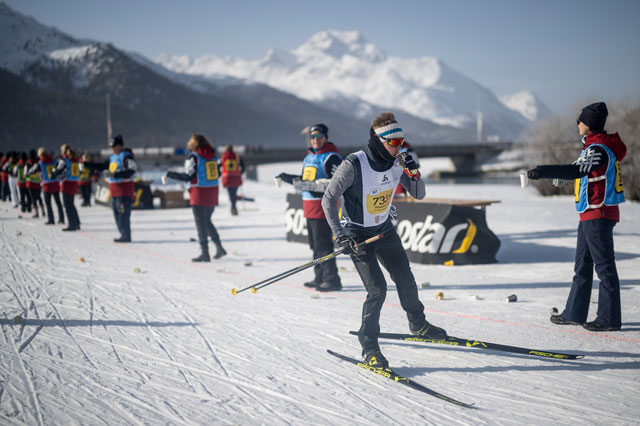 Helferinnen und Helfer am Rand der Strecke versorgen die L&auml;uferinnen mit Getr&auml;nken.