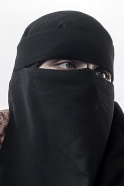 Eine Frau trägt einen schwarzen Niqab.