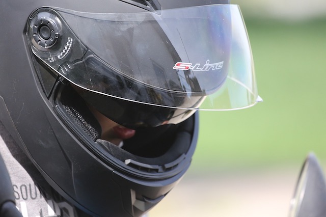 Ein Motorradfahrer trägt einen Helm mit einem Visier.