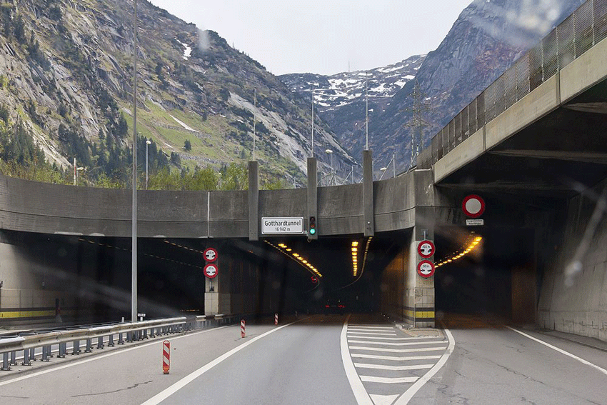 Nordportal des Gotthard-Tunnels. Die Ampel steht auf grün. Im Tunnel verschwindet eine Auto, es sind nur noch die Rücklichter zu sehen. Vor dem Tunnel ist die Strasse frei.