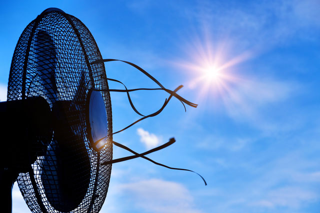 Von einem Ventilator wehen B&auml;nder im Luftstrom. Am blauen Himmel strahlt eine Sonne.