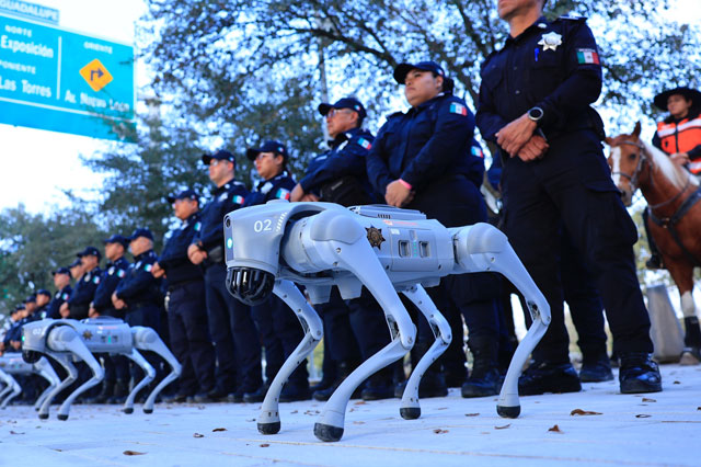 Mehrerer Roboterhunde stehen vor einer Reihe Polizistinnen und Polizisten in Achtungsstellung.