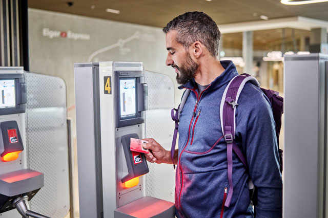 Ein Mann lädt am Automaten seinen Swisspass auf.